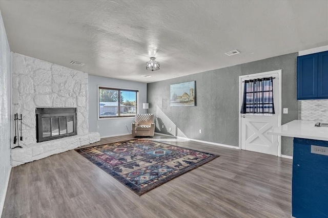 living room featuring hardwood / wood-style floors and a stone fireplace