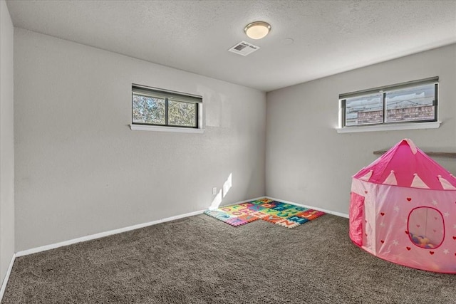 game room featuring carpet floors and a textured ceiling