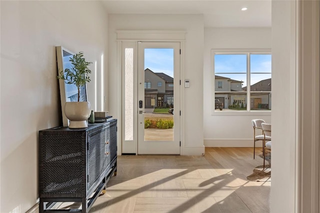 doorway with a wealth of natural light and light hardwood / wood-style flooring