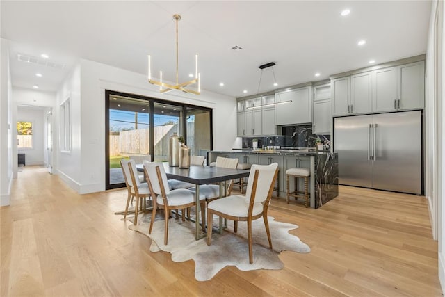 dining space featuring light hardwood / wood-style floors and an inviting chandelier