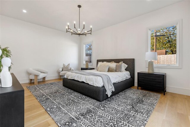 bedroom with hardwood / wood-style floors and an inviting chandelier