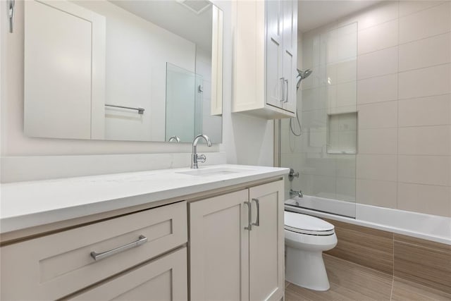 full bathroom with toilet, vanity, and tiled shower / bath