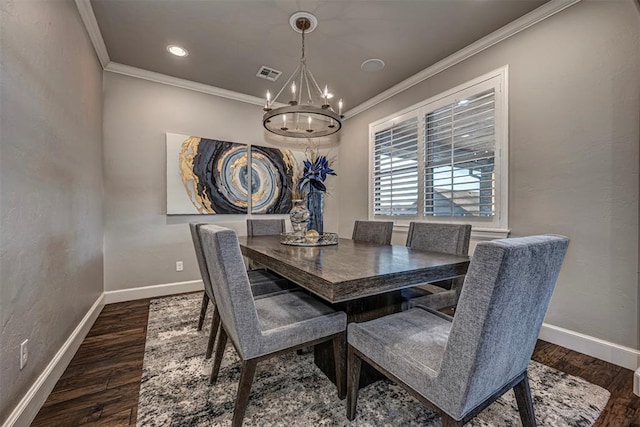 dining space featuring dark hardwood / wood-style flooring, ornamental molding, and a chandelier