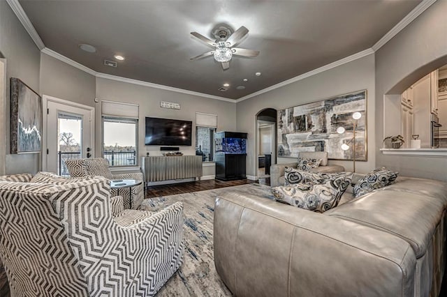 living room featuring wood-type flooring, ceiling fan, and ornamental molding