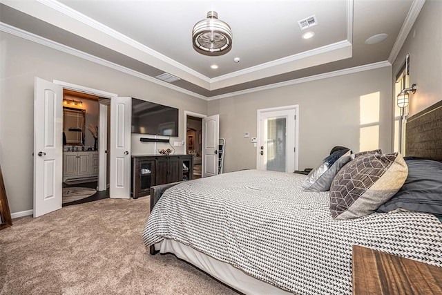 bedroom with carpet, ensuite bathroom, a tray ceiling, and crown molding