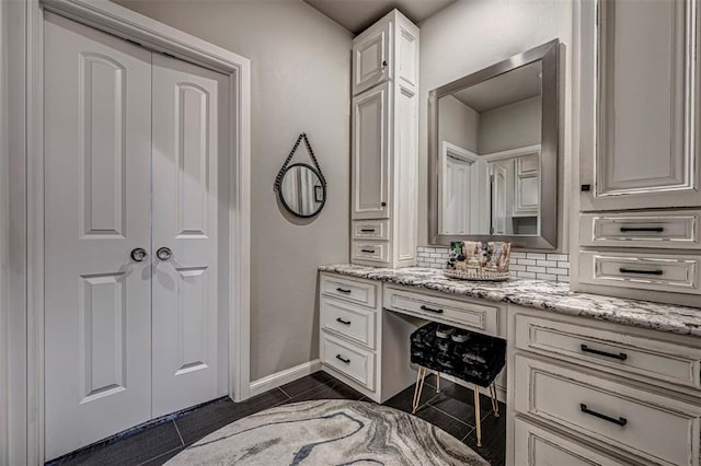 bathroom featuring tile patterned flooring, vanity, and backsplash