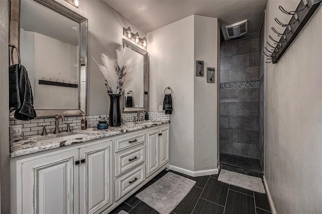 bathroom with tasteful backsplash, tile patterned floors, vanity, and walk in shower