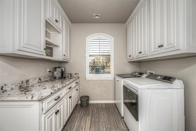 laundry area with washer and clothes dryer, cabinets, and hardwood / wood-style flooring