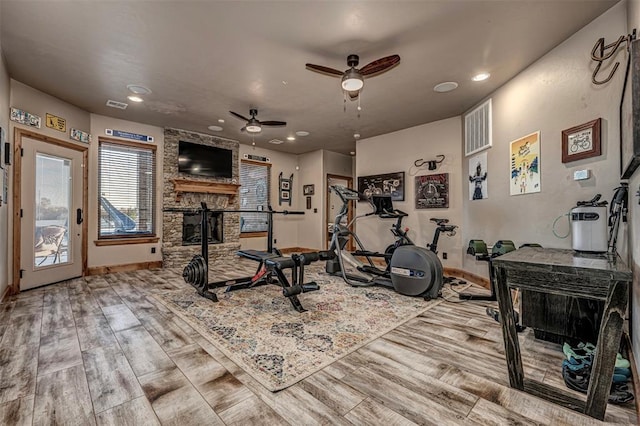 workout area with a fireplace, hardwood / wood-style floors, and ceiling fan