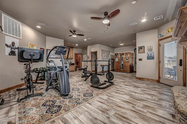 workout room with ceiling fan and light hardwood / wood-style floors