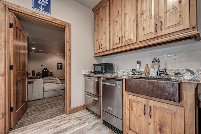 kitchen featuring light hardwood / wood-style flooring, stainless steel dishwasher, and light stone counters