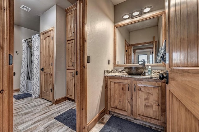 bathroom featuring shower / bath combo with shower curtain, vanity, and hardwood / wood-style flooring