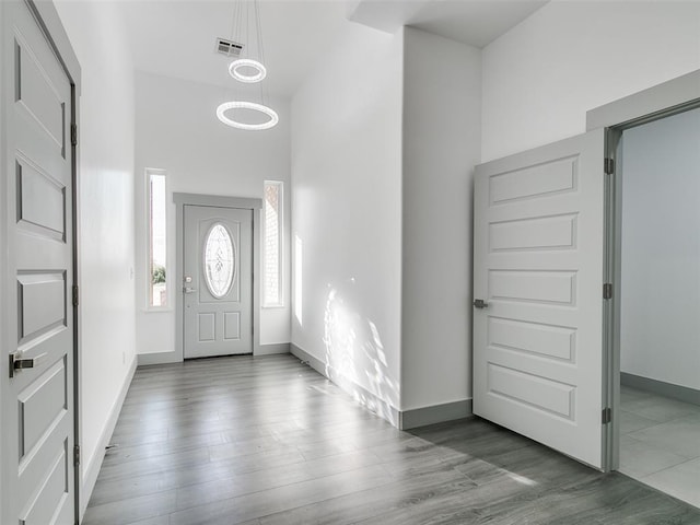 entryway with wood-type flooring and a high ceiling