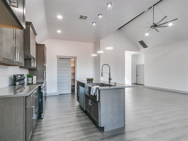 kitchen featuring pendant lighting, a center island with sink, sink, hardwood / wood-style flooring, and stainless steel appliances