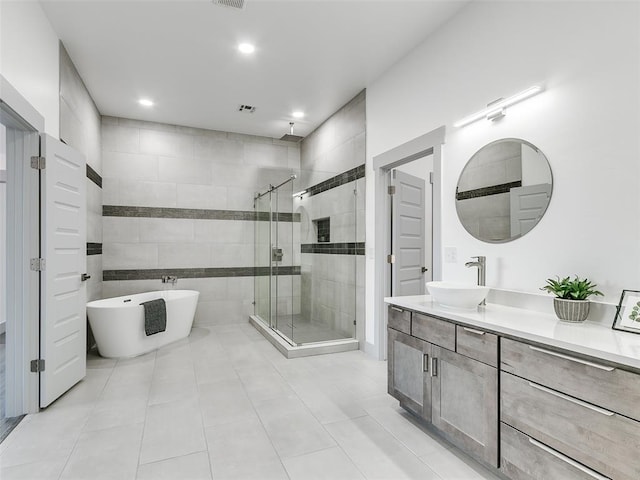 bathroom with tile patterned floors, vanity, and separate shower and tub