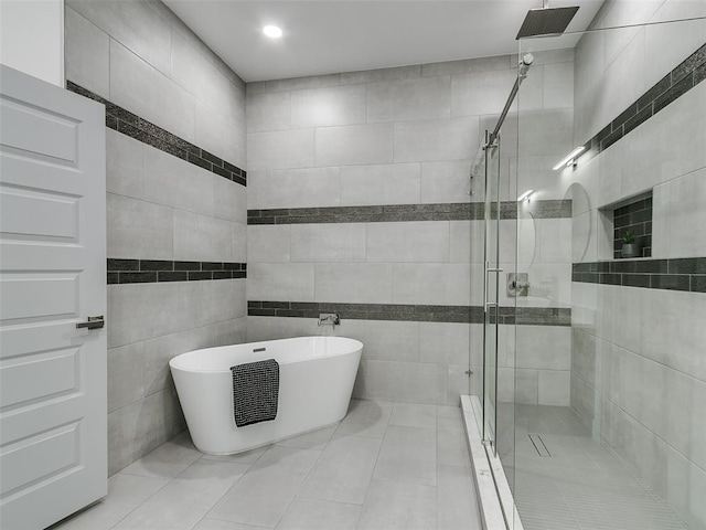 bathroom featuring tile patterned flooring, separate shower and tub, and tile walls