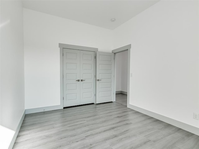 unfurnished bedroom with light hardwood / wood-style floors and a closet