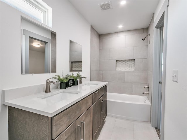 bathroom featuring tile patterned flooring, tiled shower / bath combo, and vanity