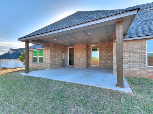 back of house with a yard and a patio