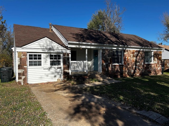 ranch-style home featuring a front lawn and covered porch