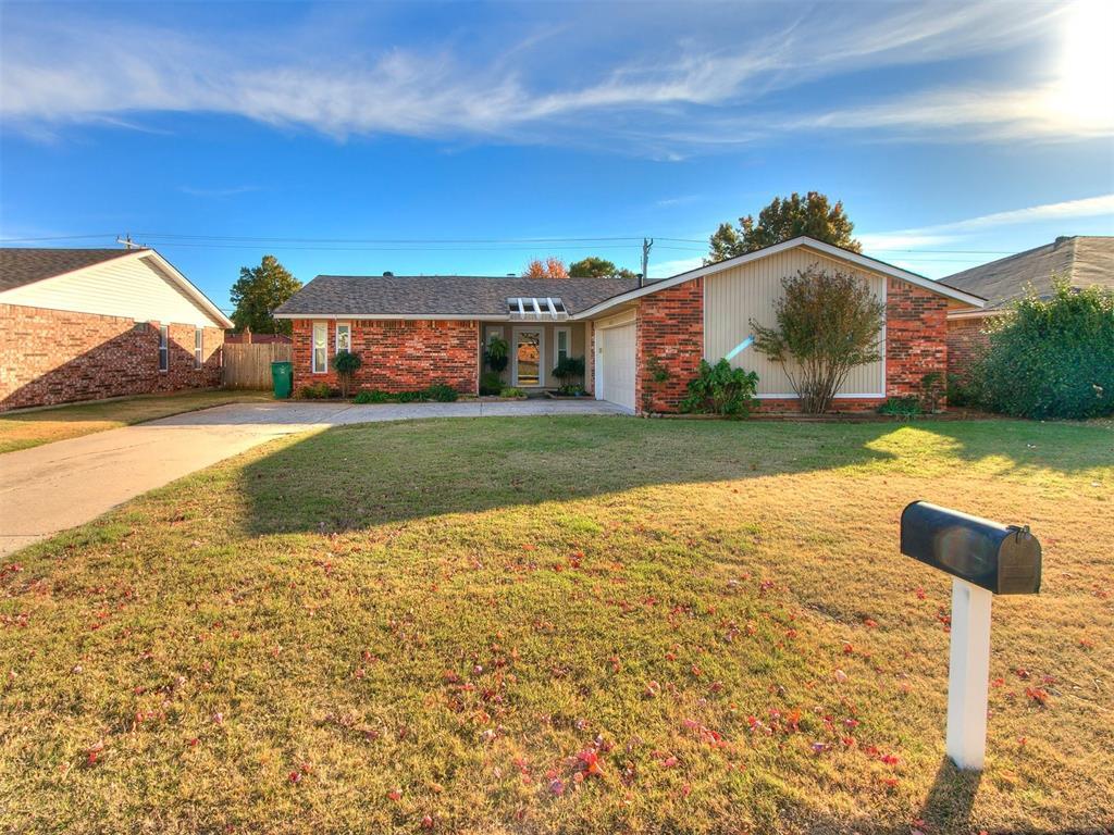 view of front of property with a garage, brick siding, driveway, and a front lawn