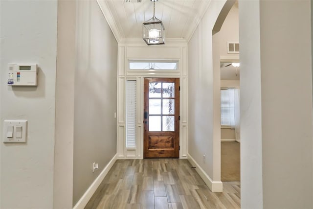 entryway with crown molding and light hardwood / wood-style floors