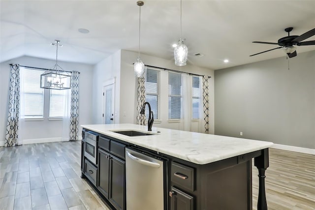 kitchen featuring appliances with stainless steel finishes, sink, an island with sink, and hanging light fixtures