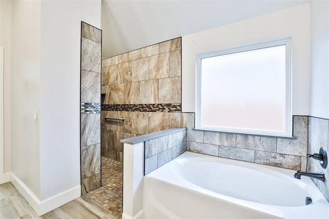 bathroom featuring plus walk in shower and wood-type flooring