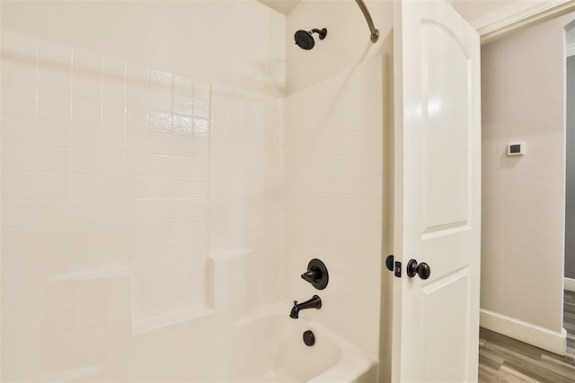 bathroom with hardwood / wood-style flooring and bathtub / shower combination