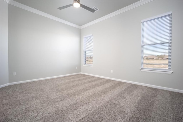 carpeted spare room featuring a wealth of natural light, ornamental molding, and ceiling fan