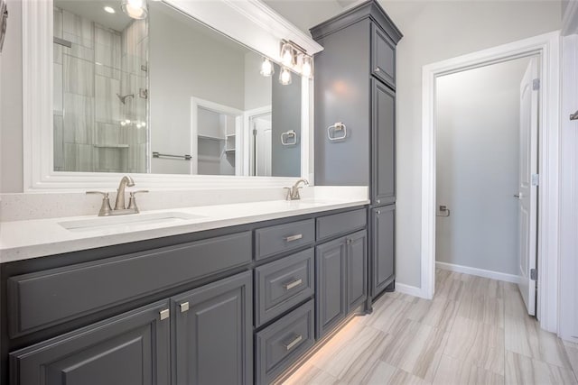 bathroom featuring tiled shower and vanity