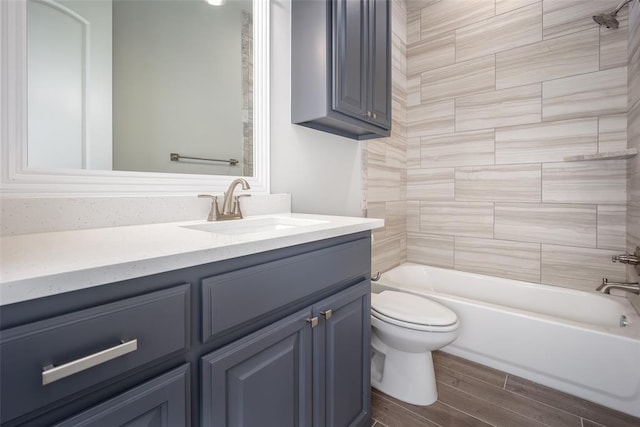 full bathroom featuring toilet, vanity, tiled shower / bath combo, and hardwood / wood-style flooring