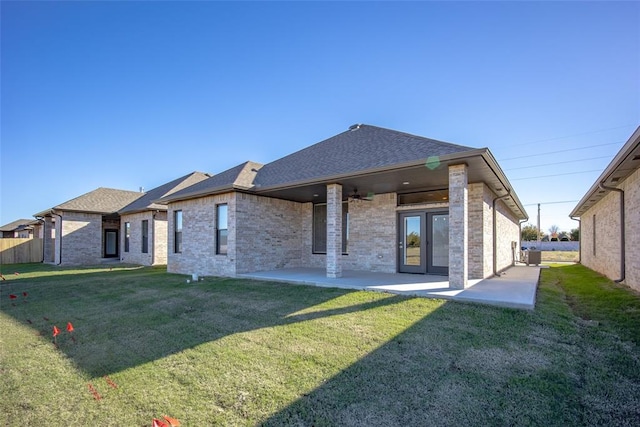 back of house featuring a lawn, central AC unit, and a patio