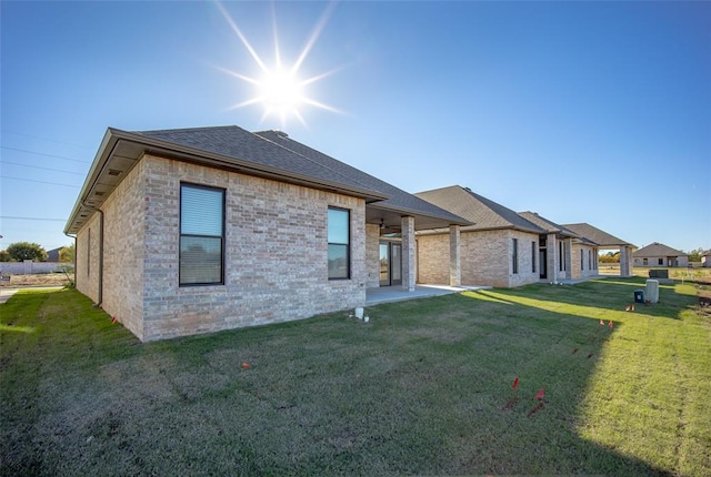 rear view of house with ceiling fan and a yard