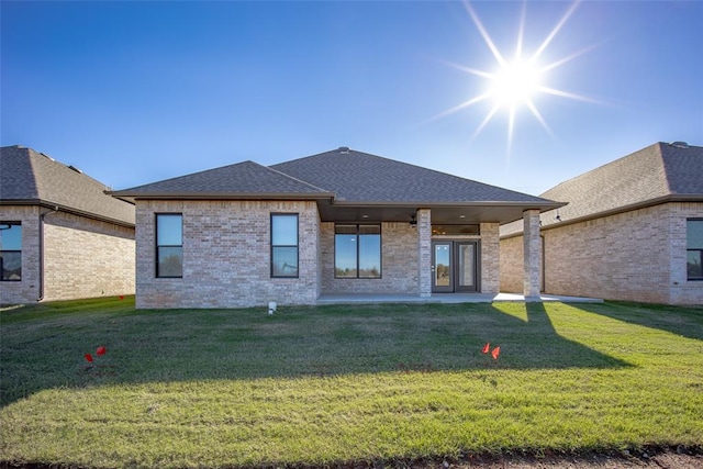 rear view of house with a lawn and a patio