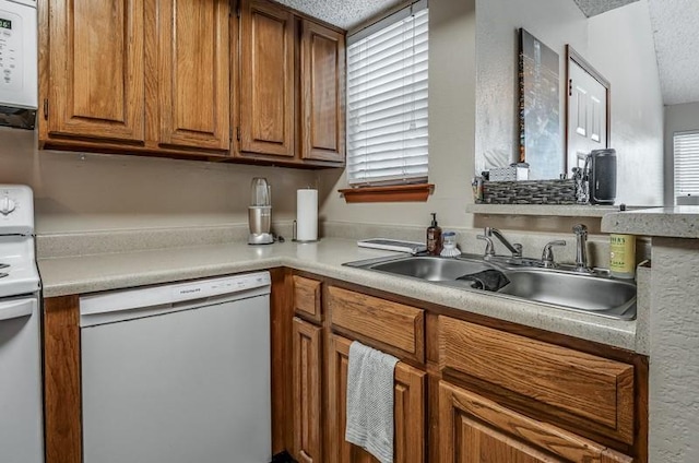 kitchen with a textured ceiling, sink, and white appliances