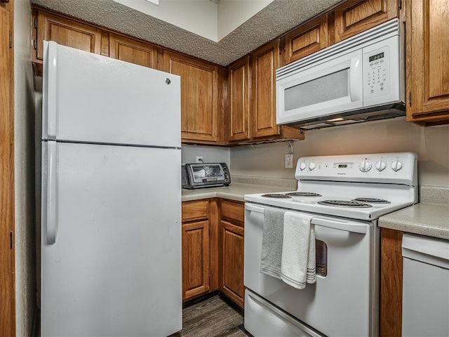 kitchen featuring dark hardwood / wood-style flooring and white appliances