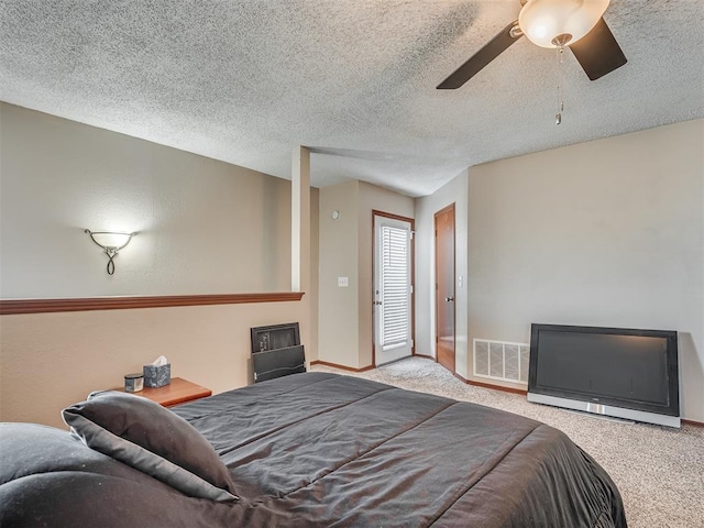 bedroom featuring ceiling fan, light colored carpet, and a textured ceiling