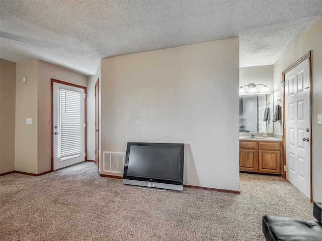 unfurnished living room featuring a textured ceiling and light carpet