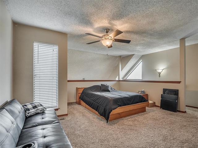 bedroom with ceiling fan, light colored carpet, and a textured ceiling