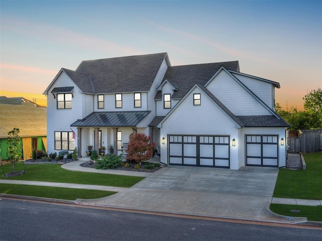 modern farmhouse featuring a garage and a yard