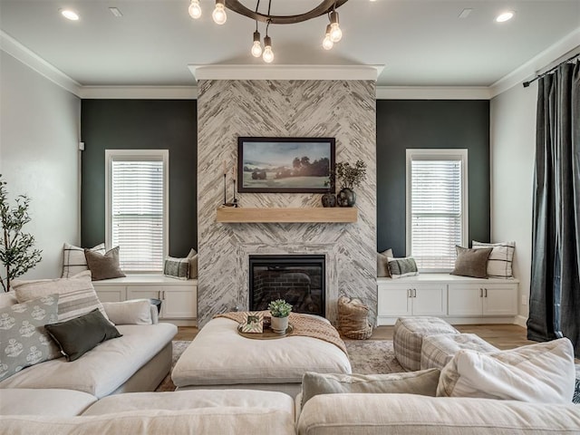 living room with a fireplace, plenty of natural light, ornamental molding, and light hardwood / wood-style flooring