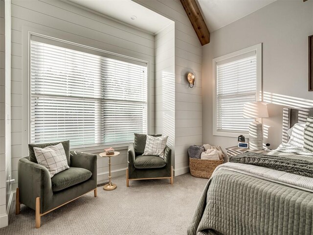 carpeted bedroom featuring vaulted ceiling with beams and multiple windows