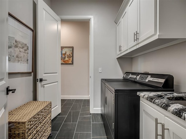 laundry area with cabinets, washer and clothes dryer, and dark tile patterned flooring