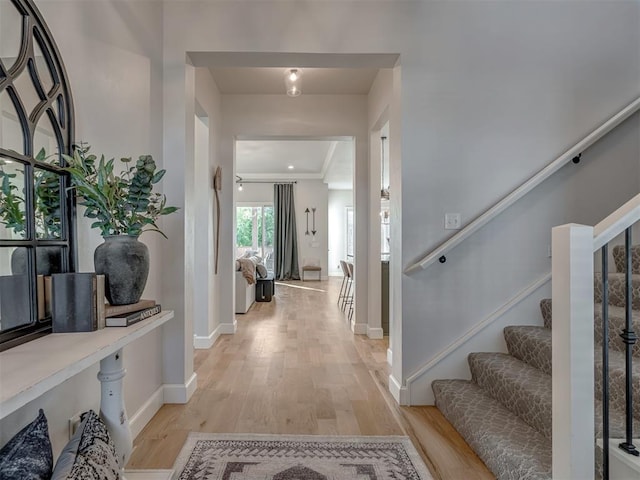 entrance foyer featuring ornamental molding and light hardwood / wood-style floors