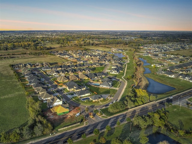 aerial view at dusk featuring a water view