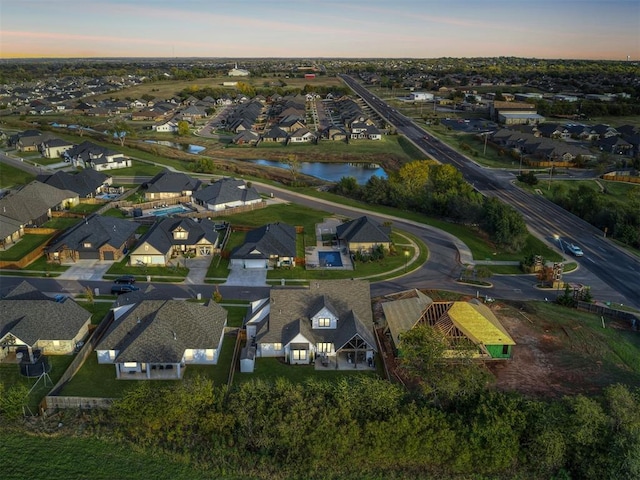 aerial view at dusk featuring a water view