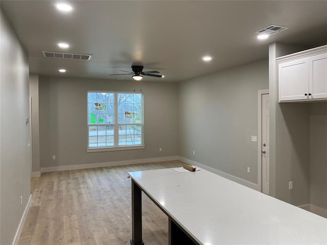 interior space featuring white cabinetry, ceiling fan, and light wood-type flooring