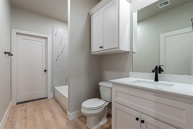 full bathroom featuring toilet, vanity, hardwood / wood-style floors, and tub / shower combination