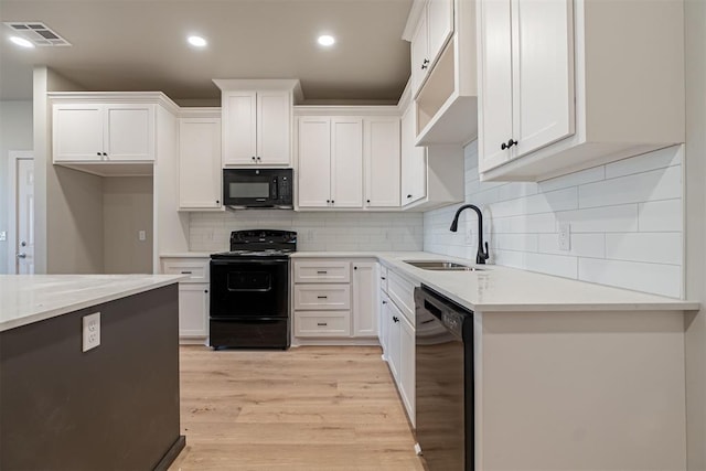 kitchen featuring black appliances and white cabinets